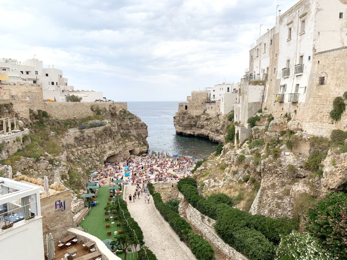 Polignano a Mare in gneča na majhni plaži.