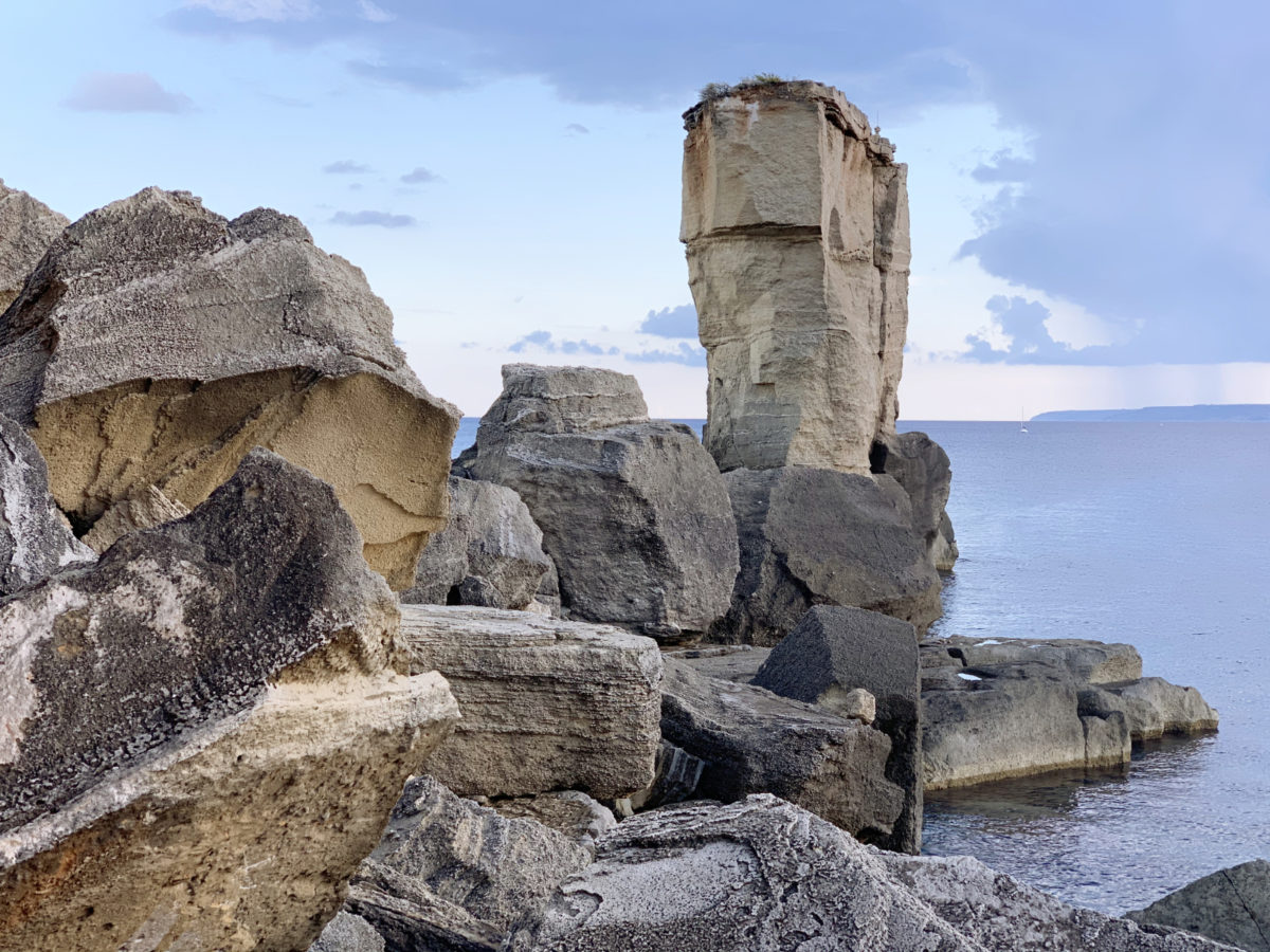 Impresivna skalna formacija ob plaži.